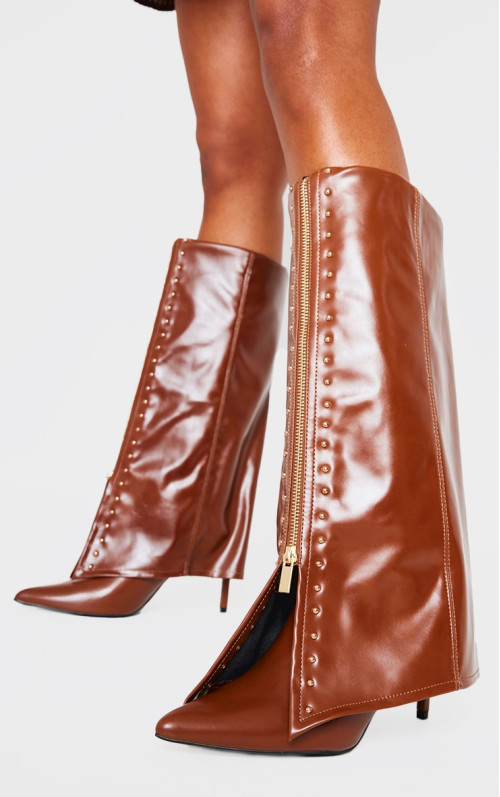 Коричневі поліуретанові золоті шпильки з гострим носом поверх високих чобіт на підборах