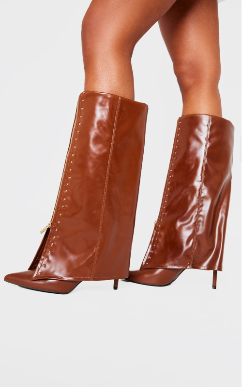 Коричневі поліуретанові золоті шпильки з гострим носом поверх високих чобіт на підборах